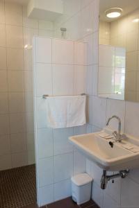 a white bathroom with a sink and a mirror at Hotel de Stoppelberg in Beekbergen