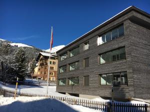 un edificio en la nieve con una bandera delante de él en Apartment Roccabella, en Davos