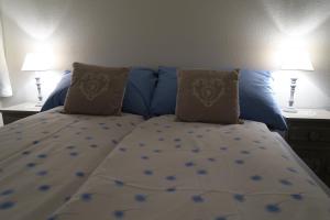 ein Bett mit blauer Bettwäsche und Kissen in einem Schlafzimmer in der Unterkunft Apartment Roccabella in Davos