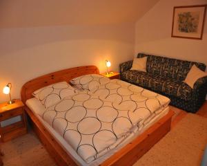 a bedroom with a bed and a couch at Ferienwohnung Regentalblick in Miltach