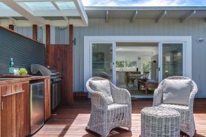 two wicker chairs sitting on the deck of a house at Capella Villa No. 2 - luxury with outdoor kitchen in Blairgowrie