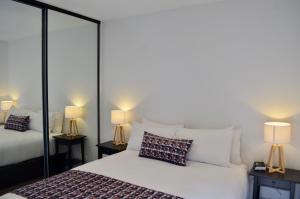 a bedroom with two beds and two lamps at Whitmore SQ in Adelaide