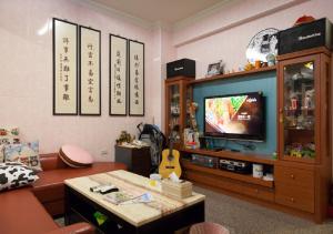 a living room with a couch and a tv at Wish Dream in Donggang
