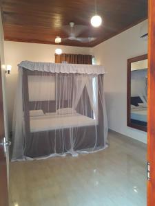 a bed with a canopy in a room at Nooit Gedacht Holiday Resort Unawatuna in Unawatuna