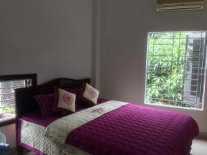a bedroom with a purple bed with a window at Hoi An beach house in Hoi An