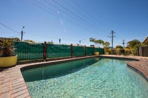 ein Schwimmbad mit einem Zaun um ihn herum in der Unterkunft Caboolture Motel in Caboolture