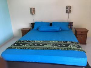 a blue bed with blue sheets and blue pillows at Repag Wayan Canggu Hostel in Canggu