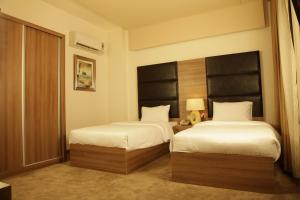 Un pat sau paturi într-o cameră la Quaint Hotel Erbil