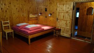 ビストシツァ・クウォツカにあるAgrowczasy Góry Bystrzyckieの木製の部屋にベッド1台が備わるベッドルーム1室があります。