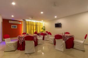 Habitación con mesas, sillas y TV. en Hotel Imperial Classic en Hyderabad