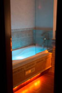 La salle de bains est pourvue d'une baignoire et d'une fenêtre en verre. dans l'établissement Estate Kalaitzis, à Vergina