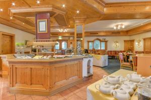 eine große Küche mit Holzdecken und ein Esszimmer in der Unterkunft Posthotel Hofherr in Königsdorf