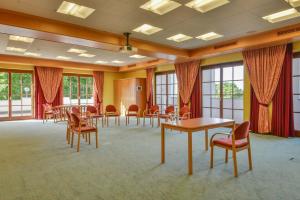 einen Konferenzraum mit Tischen, Stühlen und Fenstern in der Unterkunft Posthotel Hofherr in Königsdorf