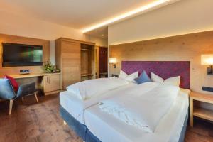 Ein Bett oder Betten in einem Zimmer der Unterkunft Posthotel Hofherr