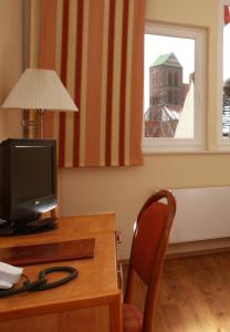 
a living room with a desk and a chair at Restaurant & Hotel Wismar in Wismar
