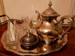 a silver tea kettle on a glass tray on a table at Maison d'Hôtes Dar Ennassim in La Marsa