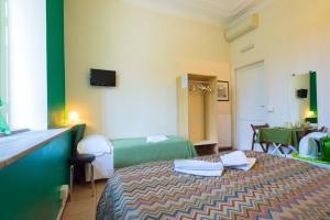 ローマにあるクォ ヴァディス ローマ 2のベッドとテーブルが備わるホテルルームです。