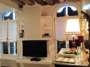 a living room with a flat screen tv and two windows at Bighouse in Venice
