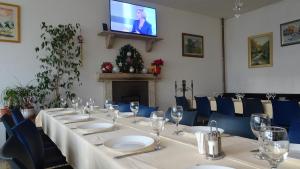 a room with a long table with chairs and a television at Business Club in Szlatina