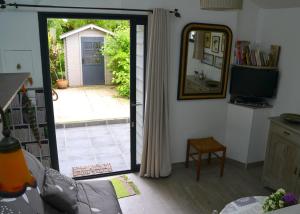 uma sala de estar com uma porta que leva a um pátio em Les Herbagettes em Nonant
