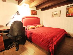 a bedroom with a red bed and a desk and a chair at Orologio del Massimo in Palermo