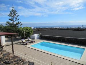a swimming pool on a patio with a view of the ocean at El Cercado in Tías +16 photos