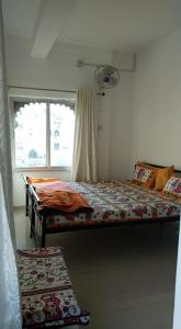 a small bedroom with a bed with a window at Bagol Palace in Udaipur