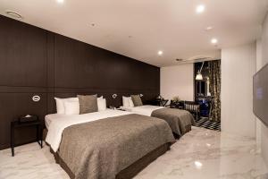 una habitación de hotel con 2 camas en una habitación en Hotel The May, en Namyangju