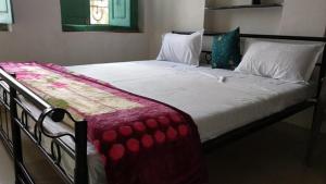 a large bed in a bedroom with a red and white blanket at Bagol Palace in Udaipur