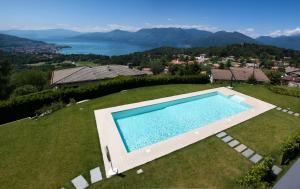 vista sull'alto di una piscina in un campo con una casa di Residenza Roggiolo a Luino