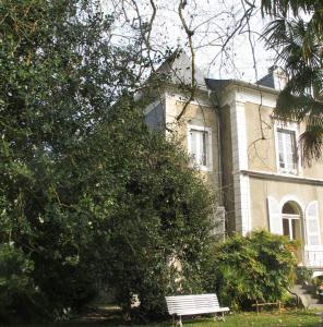 eine Bank, die vor einem Haus sitzt in der Unterkunft Villa Dampierre in Pau