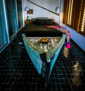 ein altes Holzboot in einem Schlafzimmer mit einem Bett in der Unterkunft Munga Guesthouse in Taghazout