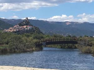 un ponte su un fiume con una città sullo sfondo di Azzurra a Posada