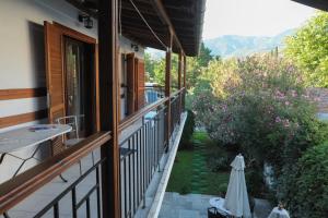 una vista exterior de una casa con una sombrilla en un patio en Spyrou Studios & Apartments, en Platanidia