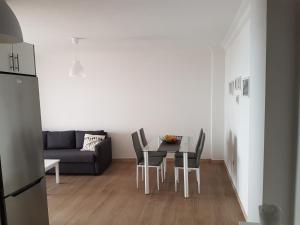 Una sala de estar con una mesa y sillas y un sofá. en El Lomo, en Santa Cruz de la Palma