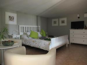 Schlafzimmer mit einem Bett, einem Tisch und einem TV in der Unterkunft El Cercado in Tías