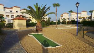 einen Golfplatz in einem Resort mit Palmen und Gebäuden in der Unterkunft casa luxury 2 nudista in Vera