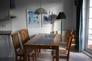 een eettafel met stoelen en een lamp bij Fewo Sommergarten 4002_LUCI in Ostseebad Karlshagen