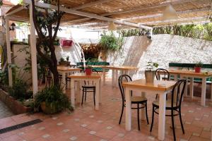 - un ensemble de tables et de chaises sur une terrasse dans l'établissement Albergo Costa, à Imperia