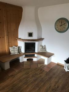 a living room with a fireplace and a clock on the wall at Ferienwohnung Franziska 2 in Garmisch-Partenkirchen