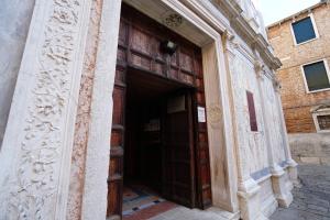 ヴェネツィアにあるカーザ コッレオーニの大きな木製のドアのある建物の入口