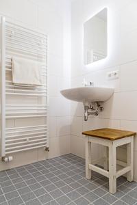 a white bathroom with a sink and a table at de Zeeuwse Hemel in Zierikzee