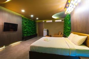 a bedroom with a bed with green plants on the walls at Sweety Resort in Bangna