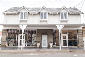 a white house with a white door and windows at The Kingsman boutique Hotel in Burgersdorp