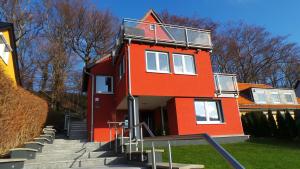 ein rotes Gebäude mit Treppen, die zu ihm führen in der Unterkunft Villa Moma in Bad Harzburg