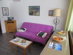 サン・フランソワ・ロンシャンにあるAppartement au pied des pistes - Saint François Longchampの紫色のソファとテーブル付きのリビングルーム
