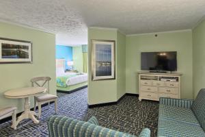 トラバースシティにあるシュガー ビーチ リゾート ホテルのベッド、テーブル、テレビが備わるホテルルームです。