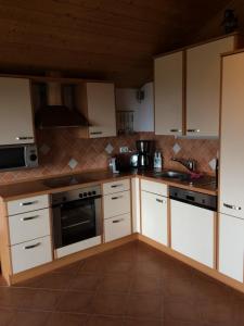 a kitchen with white cabinets and a stove top oven at Haus Eschenberg in Kirchdorf im Wald