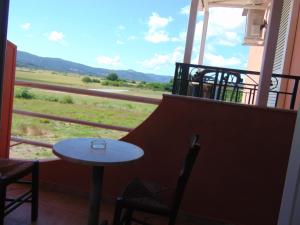 a table and chairs on a balcony with a view at Villa Magdalena studios in Ágios Ioánnis