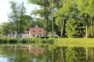 an old house on the shore of a lake at Domaine De Frevent in Échouboulains